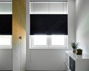 В небольшой комнате на окно установлены плотные плиссе черного цвета