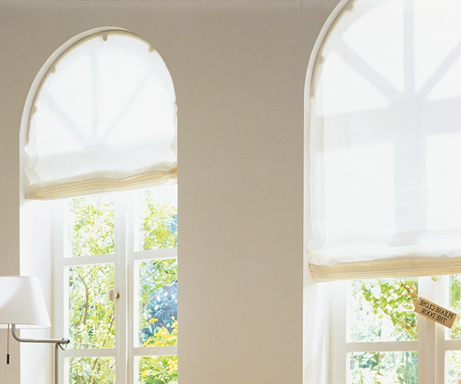 Окна со сложной формой можно отлично оформить римскими шторами, чтобы обеспечить комфорт