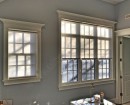 Полупрозрачные светло-бежевые мини рулонные шторы украшают деревянные окна