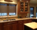 Кассетные рулонные шторы коричневого цвета установлены на кухне