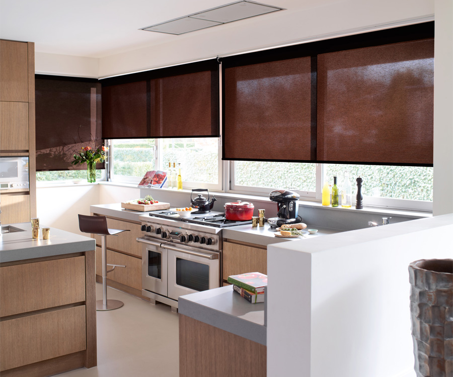 На кухне с большими окнами рулонные шторы помогут создать комфорт
