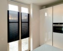 Черные полупрозрачные шторы плиссе натяжного типа на остекленных дверях