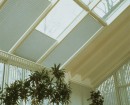 Светлые шторы плиссе отлично сочетаются на потолочных окнах в зимнем саду